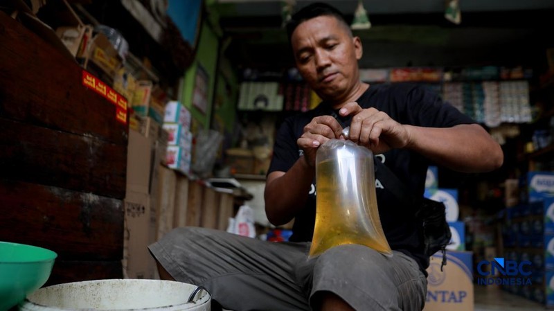 Pekerja menuang minyak curah ke dalam plastik kiloan di kawasan Pasar Pondok Labu, Jakarta Selatan, Rabu, (22/4/2026). (CNBC Indonesia/Muhammad Sabki)