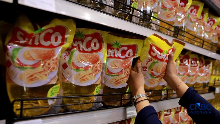 Petugas menata minyak goreng di rak sebuah ritel modern di kawasan Jakarta, Rabu, (22/4/2026). (CNBC Indonesia/Muhammad Sabki)