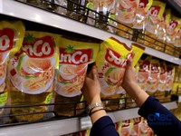 Petugas menata minyak goreng di rak sebuah ritel modern di kawasan Jakarta, Rabu, (22/4/2026). (CNBC Indonesia/Muhammad Sabki)