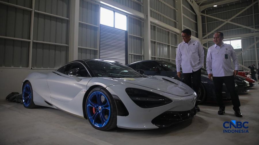 Petugas meninjau mobil sitaan Kejaksaan Agung (Kejagung) nan terparkir di instansi Badan Pemulihan Aset (BPA) Kejagung RI, Jakarta, Rabu (22/4/2026). (CNBC Indoneisa/Faisal Rahman)