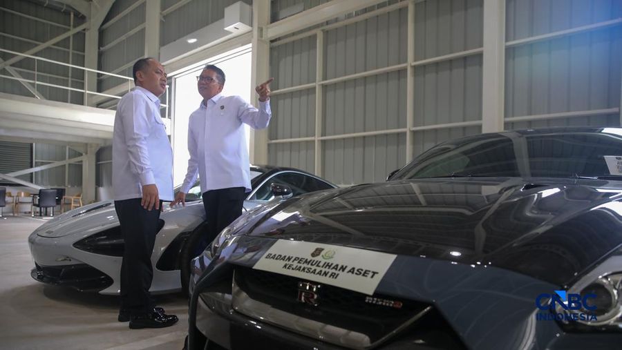 Petugas meninjau mobil sitaan Kejaksaan Agung (Kejagung) nan terparkir di instansi Badan Pemulihan Aset (BPA) Kejagung RI, Jakarta, Rabu (22/4/2026). (CNBC Indoneisa/Faisal Rahman)
