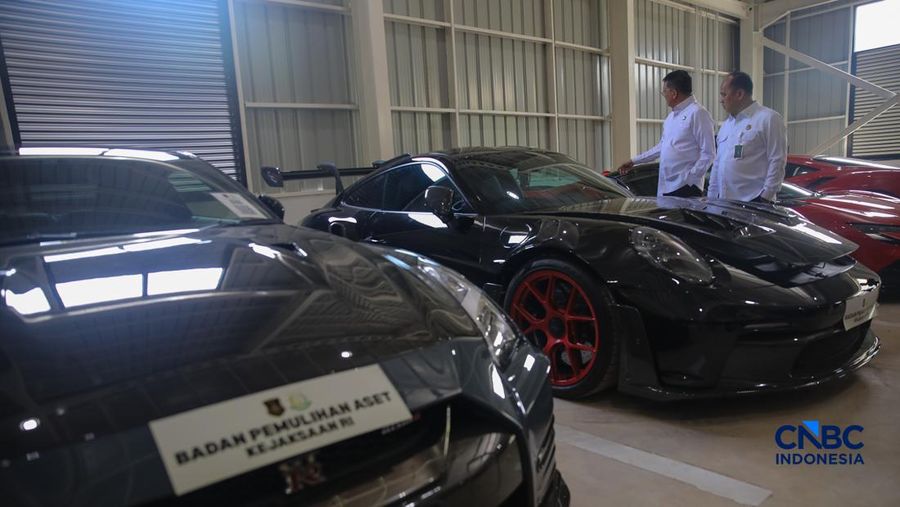 Petugas meninjau mobil sitaan Kejaksaan Agung (Kejagung) nan terparkir di instansi Badan Pemulihan Aset (BPA) Kejagung RI, Jakarta, Rabu (22/4/2026). (CNBC Indoneisa/Faisal Rahman)