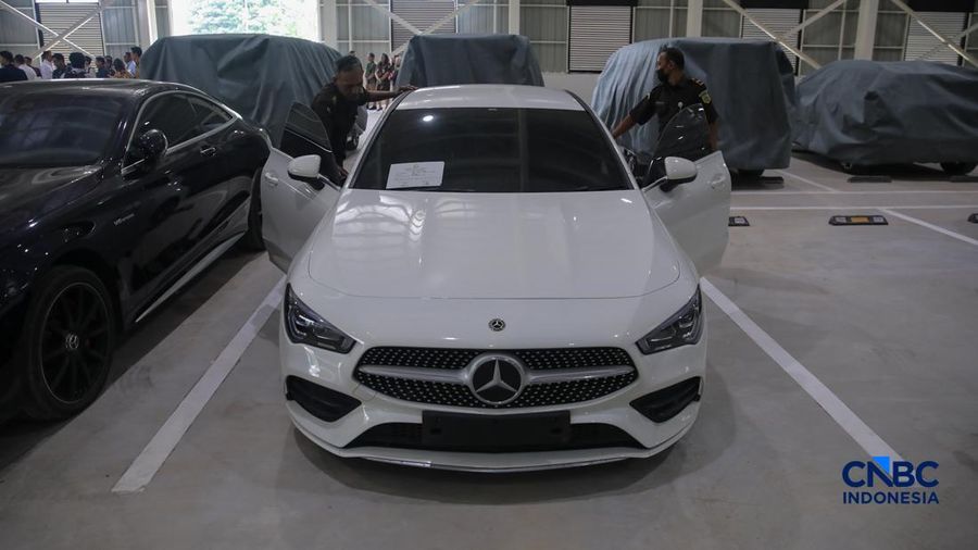 Petugas meninjau mobil sitaan Kejaksaan Agung (Kejagung) nan terparkir di instansi Badan Pemulihan Aset (BPA) Kejagung RI, Jakarta, Rabu (22/4/2026). (CNBC Indoneisa/Faisal Rahman)