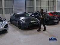 Petugas meninjau mobil sitaan Kejaksaan Agung (Kejagung) yang terparkir di kantor Badan Pemulihan Aset (BPA) Kejagung RI, Jakarta, Rabu (22/4/2026). (CNBC Indoneisa/Faisal Rahman)