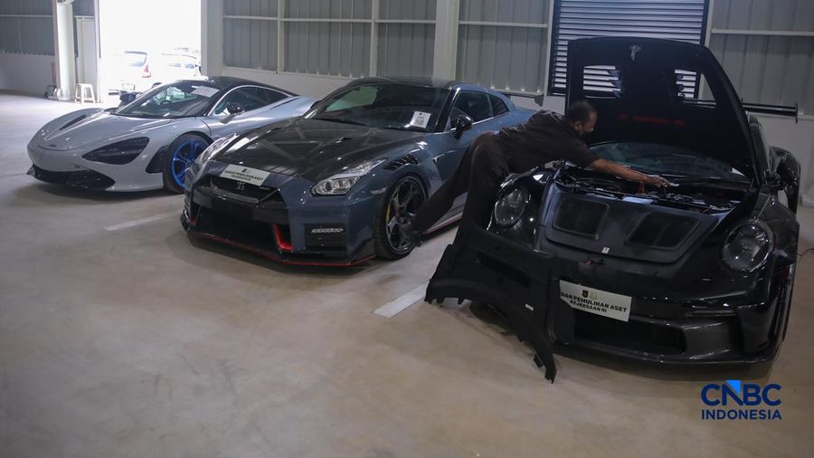 Petugas meninjau mobil sitaan Kejaksaan Agung (Kejagung) nan terparkir di instansi Badan Pemulihan Aset (BPA) Kejagung RI, Jakarta, Rabu (22/4/2026). (CNBC Indoneisa/Faisal Rahman)