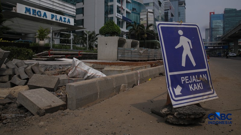 Suasana pengerjaan proyek revitalisasi di sepanjang trotoar Jalan HR Rasuna Said, kawasan Kuningan, Jakarta, Rabu (22/4/2026). (CNBC Indonesia/Faisal Rahman)