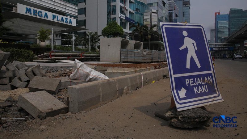 Suasana pengerjaan proyek revitalisasi di sepanjang trotoar Jalan HR Rasuna Said, kawasan Kuningan, Jakarta, Rabu (22/4/2026).