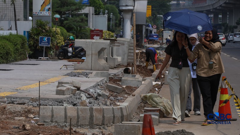 Suasana pengerjaan proyek revitalisasi di sepanjang trotoar Jalan HR Rasuna Said, kawasan Kuningan, Jakarta, Rabu (22/4/2026). (CNBC Indonesia/Faisal Rahman)