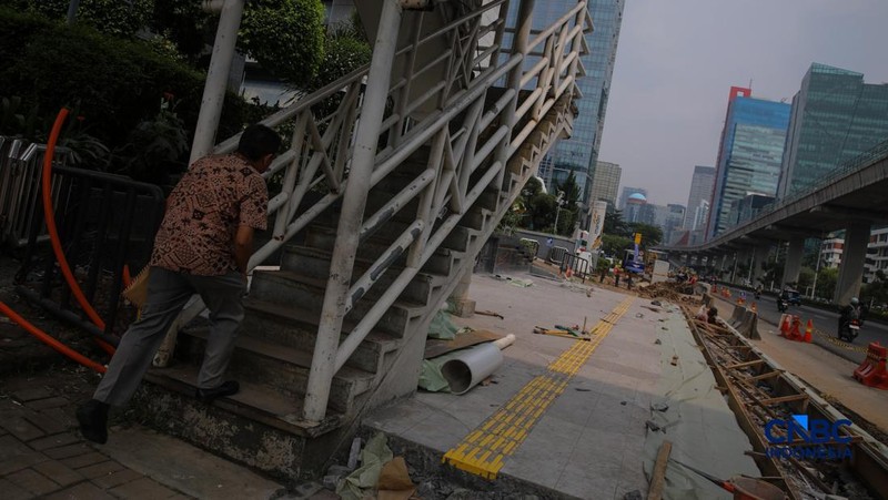 Suasana pengerjaan proyek revitalisasi di sepanjang trotoar Jalan HR Rasuna Said, kawasan Kuningan, Jakarta, Rabu (22/4/2026).