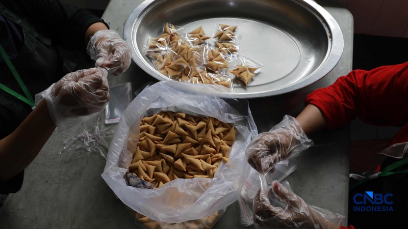 Aktivitas di dapur Asrama Haji Pondok Gede, Jakarta, terlihat sibuk pada Kamis (23/4/2026). Para petugas dapur haji tampak menyiapkan berbagai makanan, termasuk snack box, untuk memenuhi kebutuhan konsumsi calon jemaah haji. (CNBC Indonesia/Muhammad Sabki)