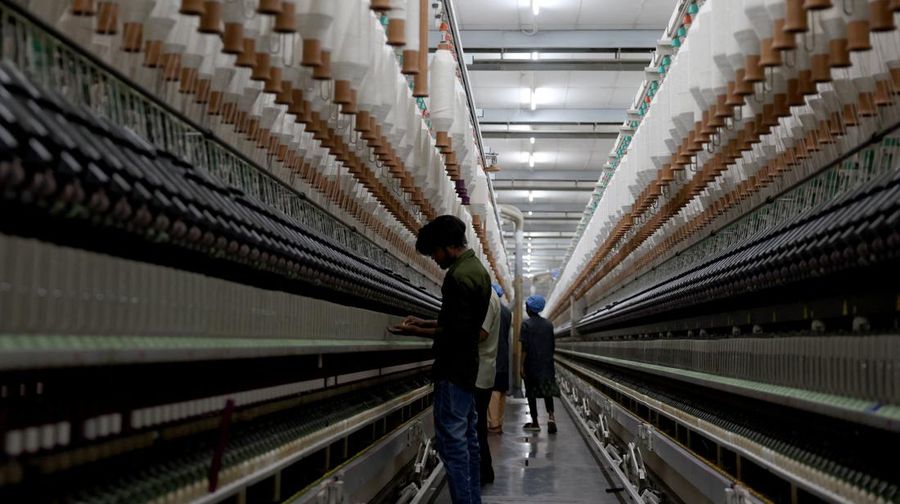 Para karyawan bekerja di dalam pabrik pembuatan benang katun Fiotex Cotspin di Rajkot, Gujarat, India, 14 April 2026.