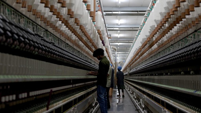 Para karyawan bekerja di dalam pabrik pembuatan benang katun Fiotex Cotspin di Rajkot, Gujarat, India, 14 April 2026.