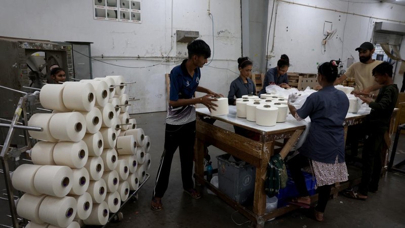 Para karyawan mengemas benang katun di dalam pabrik pembuatan benang katun Fiotex Cotspin di Rajkot, Gujarat, India, 14 April 2026.