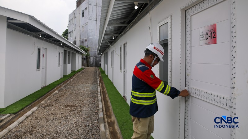 Pekerja merapikan tempat tidur pada salah satu unit hunian sementara (Huntara) di Jalan Kramat Raya, Jakarta, Kamis (23/4/2026). (CNBC Indonesia/Faisal Rahman)