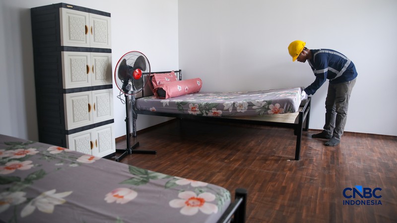 Pekerja merapikan tempat tidur pada salah satu unit hunian sementara (Huntara) di Jalan Kramat Raya, Jakarta, Kamis (23/4/2026). (CNBC Indonesia/Faisal Rahman)