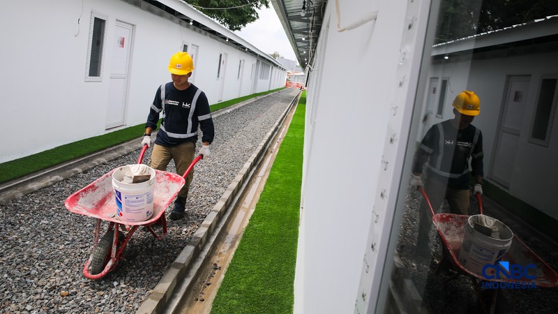 Pekerja merapikan tempat tidur pada salah satu unit hunian sementara (Huntara) di Jalan Kramat Raya, Jakarta, Kamis (23/4/2026). (CNBC Indonesia/Faisal Rahman)