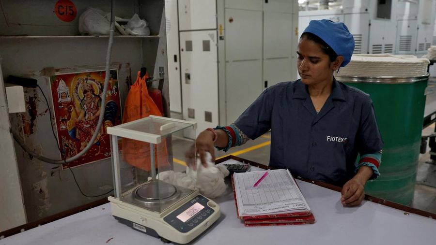 Seorang karyawan menimbang benang katun di dalam pabrik pembuatan benang katun Fiotex Cotspin di Rajkot, Gujarat, India, 14 April 2026.