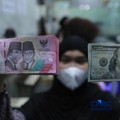 Karyawan menghitung uang pecahan dolar Amerika Serikat (AS) di gerai penukaran mata uang asing, Jakarta, Jumat (24/4/2026). (CNBC Indonesia/Muhammad Sabki)
