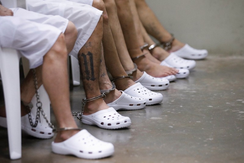 Para terduga anggota geng Mara Salvatrucha, juga dikenal sebagai MS-13, menghadiri sidang terbuka dalam persidangan massal, setelah 486 terduga anggota geng didakwa dengan lebih dari 47.000 kejahatan yang dilakukan antara tahun 2012 dan 2022, menurut jaksa, di Pusat Penahanan Terorisme (CECOT) di Tecoluca, El Salvador, 23 April 2026. (REUTERS/Jose Cabezas)