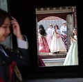 Para turis wanita yang mengenakan pakaian tradisional Korea, Hanbok, berbagi momen di Istana Gyeongbokgung di Seoul, Korea Selatan, 26 Maret 2026. (REUTERS/Kim Hong-Ji)