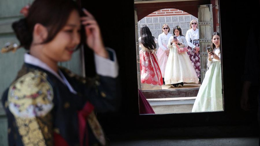 Para turis wanita yang mengenakan pakaian tradisional Korea, Hanbok, berbagi momen di Istana Gyeongbokgung di Seoul, Korea Selatan, 26 Maret 2026. (REUTERS/Kim Hong-Ji)