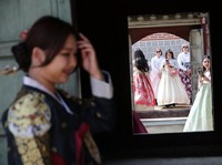 Para turis wanita yang mengenakan pakaian tradisional Korea, Hanbok, berbagi momen di Istana Gyeongbokgung di Seoul, Korea Selatan, 26 Maret 2026. (REUTERS/Kim Hong-Ji)