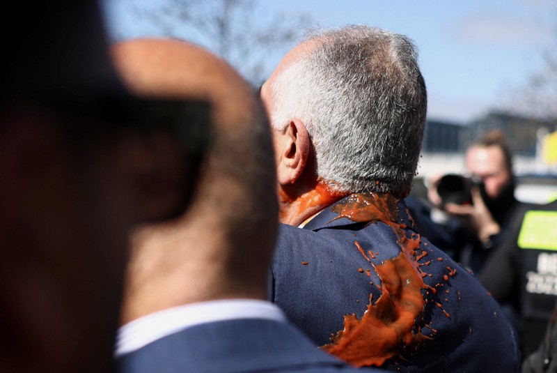 Reza Pahlavi disiram cairan merah oleh demonstran saat berkunjung ke Berlin, Jerman, pada Kamis (23/4/2026). (REUTERS/Christian Mang)