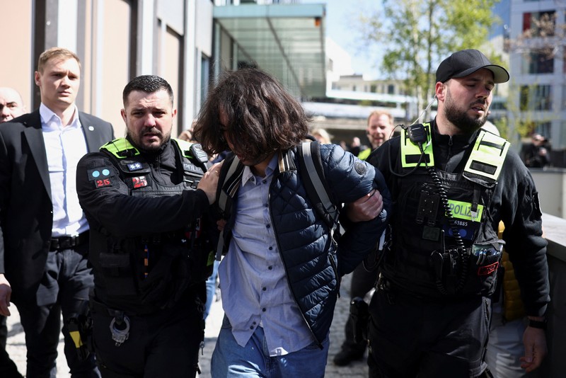 Reza Pahlavi disiram cairan merah oleh demonstran saat berkunjung ke Berlin, Jerman, pada Kamis (23/4/2026). (REUTERS/Christian Mang)