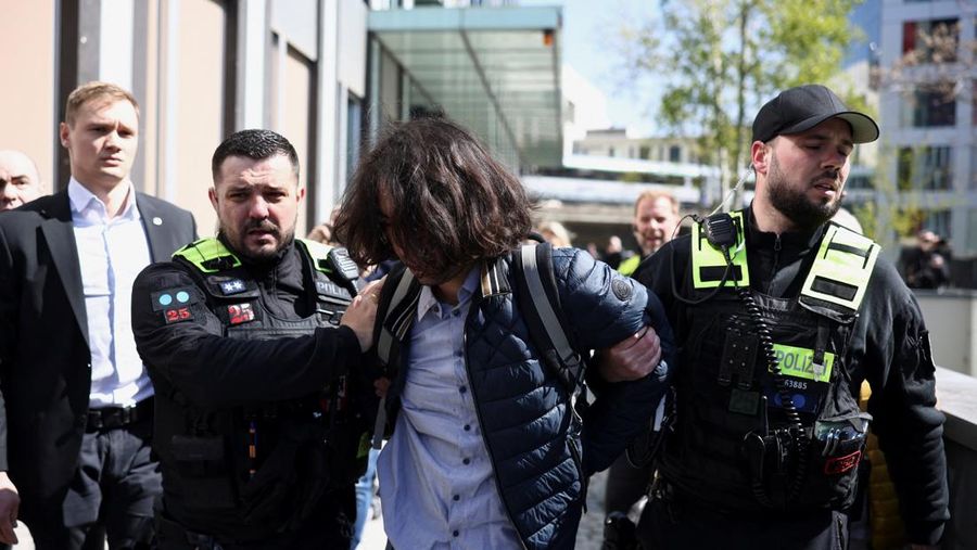 Reza Pahlavi disiram cairan merah oleh demonstran saat berkunjung ke Berlin, Jerman, pada Kamis (23/4/2026). (REUTERS/Christian Mang)