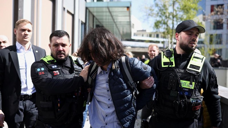 Reza Pahlavi disiram cairan merah oleh demonstran saat berkunjung ke Berlin, Jerman, pada Kamis (23/4/2026). (REUTERS/Christian Mang)