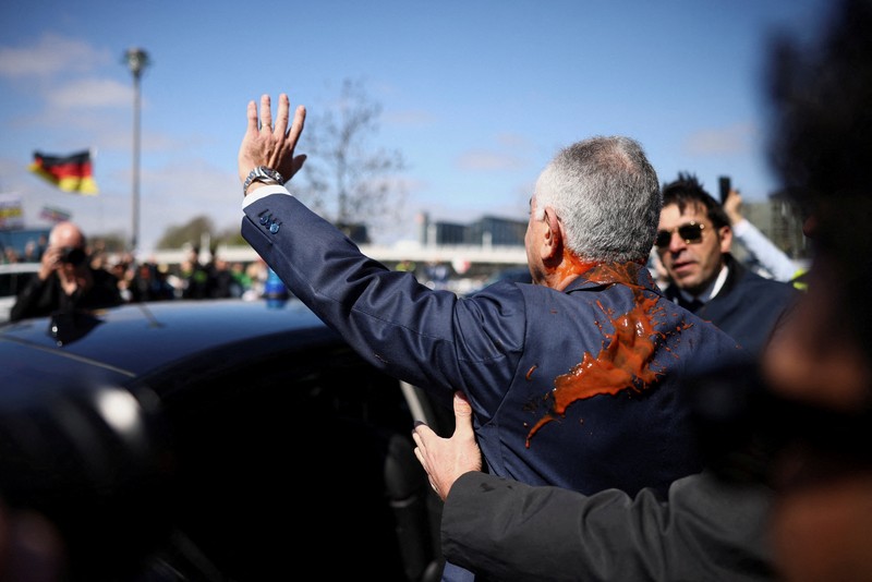 Reza Pahlavi disiram cairan merah oleh demonstran saat berkunjung ke Berlin, Jerman, pada Kamis (23/4/2026). (REUTERS/Christian Mang)