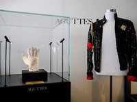 Sarung tangan kristal Swarovski buatan khusus yang dikenakan Michael Jackson di atas panggung selama tur dunia "Bad" dan jaket payet hitamnya dengan tanda "002 MJJ 87" dan "Proto 2" (1987) dipajang sebelum lelang koleksi yang didedikasikan untuk Mich