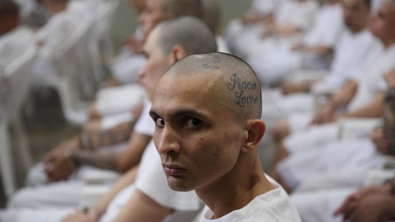 Seorang terduga anggota geng Mara Salvatrucha, juga dikenal sebagai MS-13, menghadiri sidang terbuka dalam persidangan massal, setelah 486 terduga anggota geng didakwa dengan lebih dari 47.000 kejahatan yang dilakukan antara tahun 2012 dan 2022, menurut jaksa, di Pusat Penahanan Terorisme (CECOT) di Tecoluca, El Salvador, 23 April 2026.