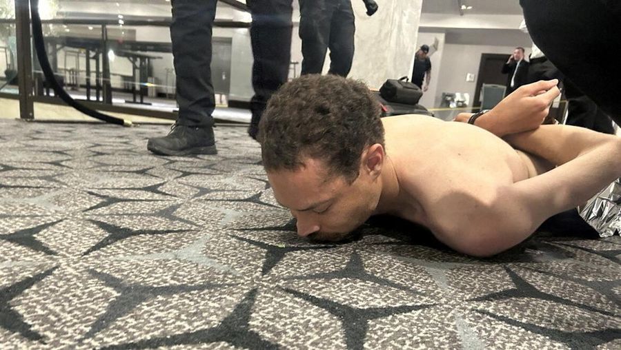 Personel penegak hukum menahan Cole Tomas Allen, tersangka dalam insiden penembakan di acara makan malam Asosiasi Koresponden Gedung Putih, di Washington, D.C., AS, 25 April 2026. (DONALD J TRUMP via Truth Social/Handout via REUTERS)