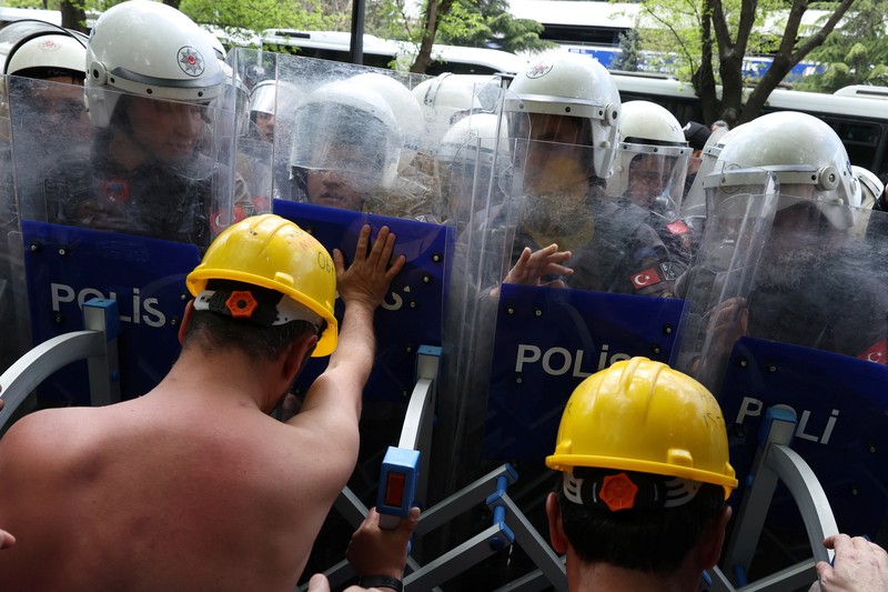 Polisi menghalangi para penambang Doruk Madencilik yang melakukan mogok makan untuk berbaris ke kementerian energi di Ankara, Turki, Senin (27/4/2026). (REUTERS/Efekan Akyuz)