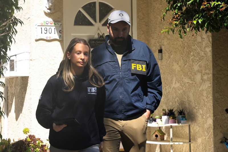An FBI member stands outside a building next to the house associated with Cole Tomas Allen, the suspect in the shooting incident in Washington at the annual White House Correspondents' Association dinner, in Torrance, California, U.S., April 26, 2026.  REUTERS/David Swanson