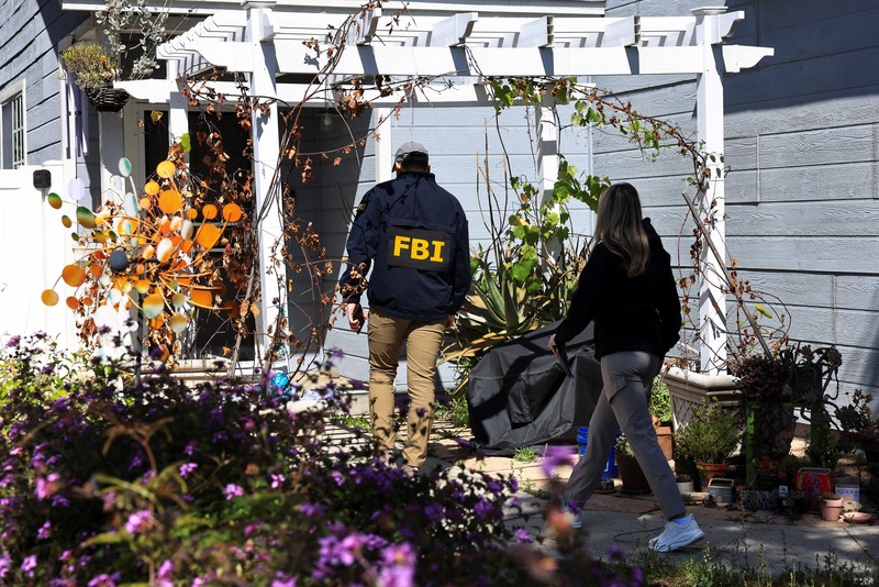 An FBI member stands outside a building next to the house associated with Cole Tomas Allen, the suspect in the shooting incident in Washington at the annual White House Correspondents' Association dinner, in Torrance, California, U.S., April 26, 2026.  REUTERS/David Swanson
