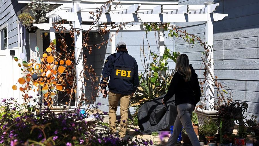 An FBI member walks up to a building next to the house associated with Cole Tomas Allen, the suspect in the shooting incident in Washington at the annual White House Correspondents' Association dinner, in Torrance, California, U.S., April 26, 2026.