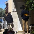 An FBI member stands outside a building next to the house associated with Cole Tomas Allen, the suspect in the shooting incident in Washington at the annual White House Correspondents' Association dinner, in Torrance, California, U.S., April 26, 2026