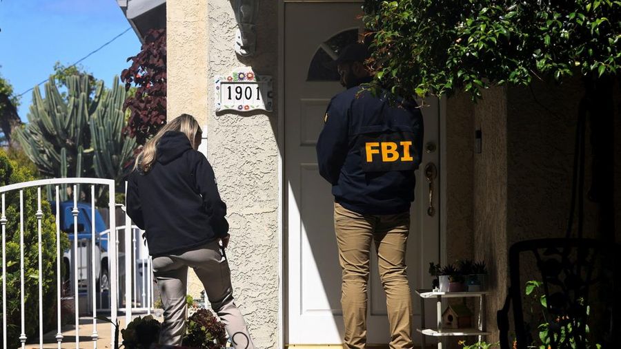 An FBI member stands outside a building next to the house associated with Cole Tomas Allen, the suspect in the shooting incident in Washington at the annual White House Correspondents' Association dinner, in Torrance, California, U.S., April 26, 2026