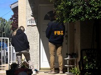 An FBI member stands outside a building next to the house associated with Cole Tomas Allen, the suspect in the shooting incident in Washington at the annual White House Correspondents' Association dinner, in Torrance, California, U.S., April 26, 2026
