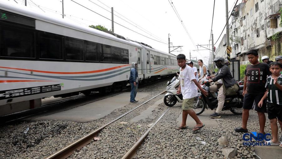Kereta Krl melintas disamping taksi Green SM yang tertabrak KRL di perlintasan kereta Jalan Ampera, Bekasi, Selasa (28/4/2026). (CNBC Indonesia/Muhammad Sabki)