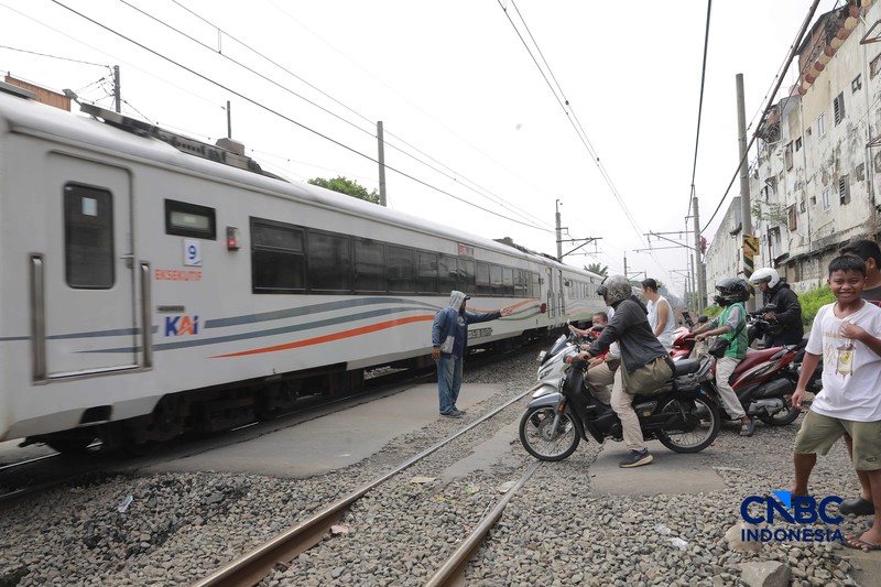 Warga melintasi perlintasan kereta Jalan Ampera, Bekasi, Selasa (28/4/2026). (CNBC Indonesia/Muhammad Sabki)