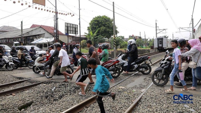Kereta Krl melintas disamping taksi Green SM yang tertabrak KRL di perlintasan kereta Jalan Ampera, Bekasi, Selasa (28/4/2026). (CNBC Indonesia/Muhammad Sabki)