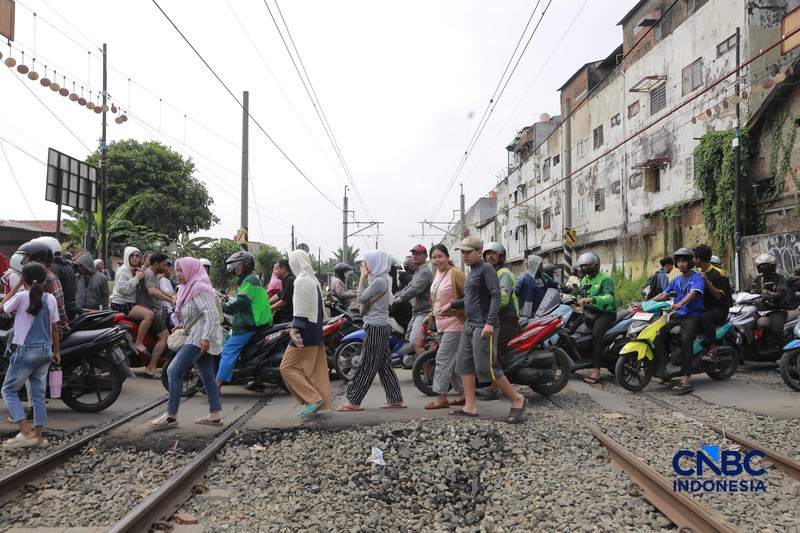 Kereta Krl melintas disamping taksi Green SM yang tertabrak KRL di perlintasan kereta Jalan Ampera, Bekasi, Selasa (28/4/2026). (CNBC Indonesia/Muhammad Sabki)