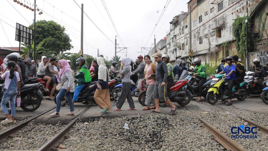 Kereta Krl melintas disamping taksi Green SM yang tertabrak KRL di perlintasan kereta Jalan Ampera, Bekasi, Selasa (28/4/2026). (CNBC Indonesia/Muhammad Sabki)
