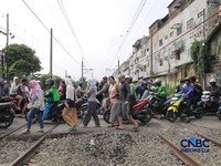 KA Jarak Jauh melintas di samping taksi Green SM yang tertabrak KRL di perlintasan kereta Jalan Ampera, Bekasi, Selasa (28/4/2026). Perlintasan ini berjarak 300 meter dari Stasiun Bekasi Timur. (CNBC Indonesia/Muhammad Sabki)