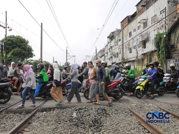 KA Jarak Jauh melintas di samping taksi Green SM yang tertabrak KRL di perlintasan kereta Jalan Ampera, Bekasi, Selasa (28/4/2026). Perlintasan ini berjarak 300 meter dari Stasiun Bekasi Timur. (CNBC Indonesia/Muhammad Sabki)