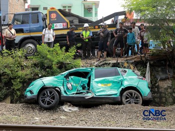 Kereta Krl melintas disamping taksi Green SM yang tertabrak KRL di perlintasan kereta Jalan Ampera, Bekasi, Selasa (28/4/2026). (CNBC Indonesia/Muhammad Sabki)