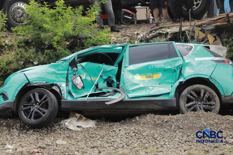 Kereta Krl melintas disamping taksi Green SM yang tertabrak KRL di perlintasan kereta Jalan Ampera, Bekasi, Selasa (28/4/2026). (CNBC Indonesia/Muhammad Sabki)